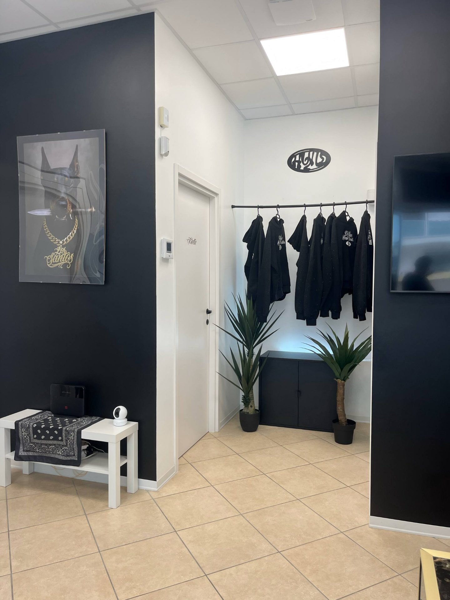 Ingresso dello studio Los Santos con merch e cornice Doberman