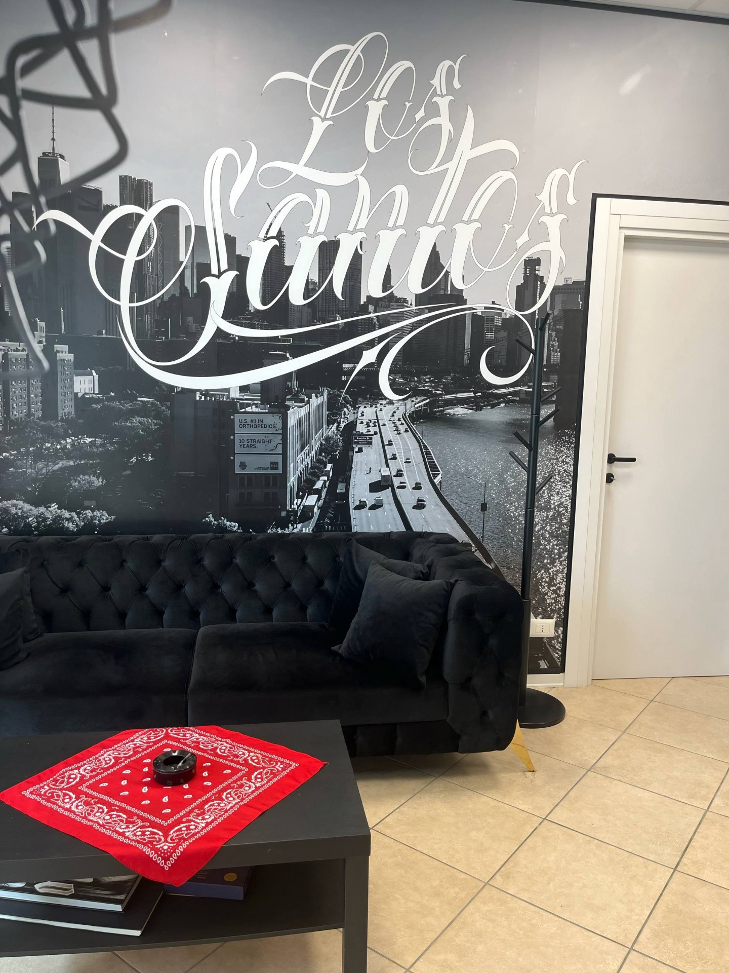 Interno del Los Santos Tattoo Shop — bancone in marmo nero con logo Los Santos in oro